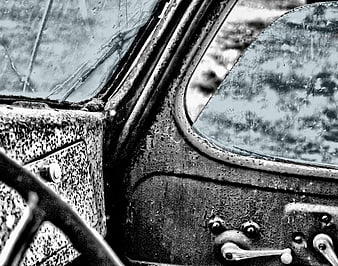 Close-up of weathered vintage car cockpit interior in black and white