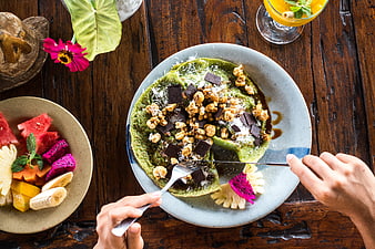 Top View of Matcha Pancakes with Tropical Fruit and Hands Eating