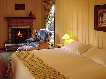 Cozy Bedroom Interior With Brick Fireplace And Plaid Blanket