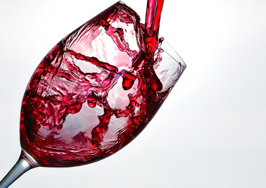 Red Wine Pouring Splash in Glass on White Background