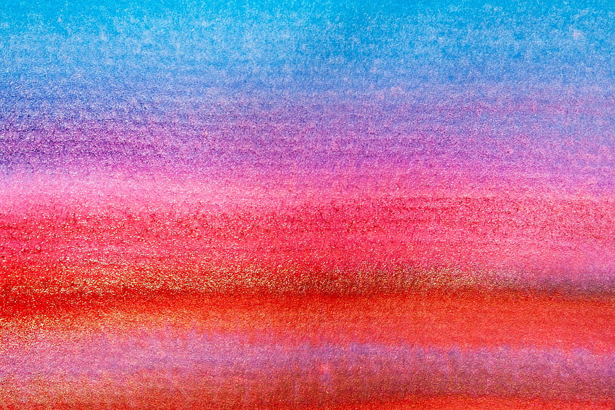 Abstract watercolor texture with blue, pink, and red gradient