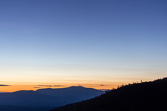 Serene Mountain Silhouette at Sunset with Blue Sky