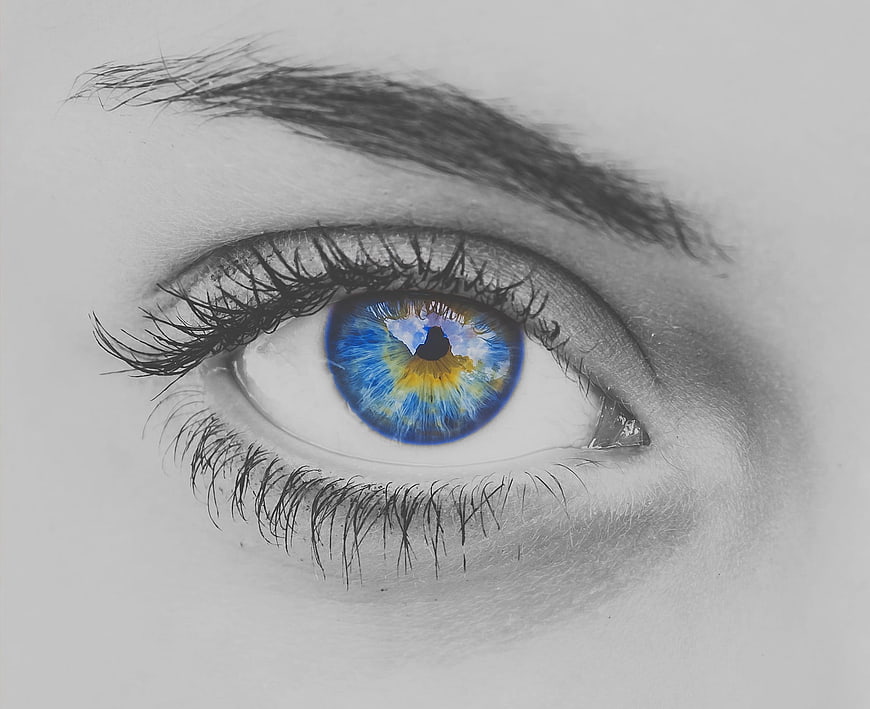Close-up of eye with colorful iris in black and white portrait