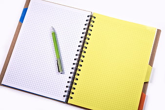 Open spiral notebook with grid paper and green pen on white background