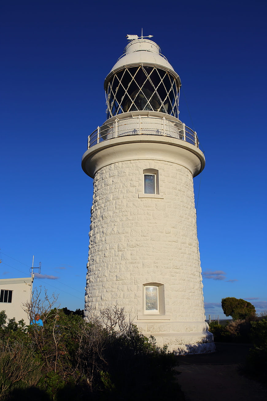 White stone lighthouse against deep blue sky