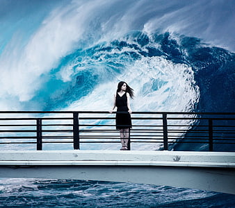 Woman in black dress standing on bridge before giant wave