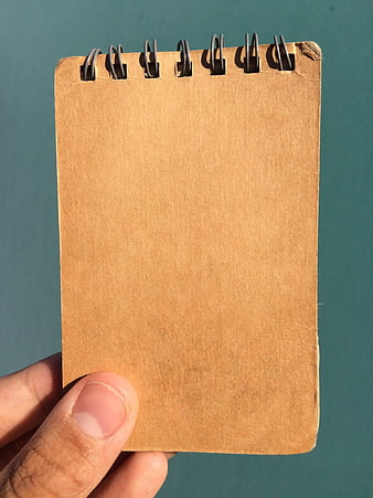 Hand holding blank kraft paper spiral notepad