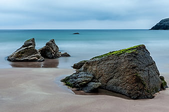 Long Exposure Mossy Rocks on Sandy Beach