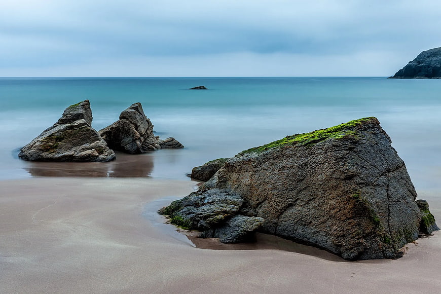 Long Exposure Mossy Rocks on Sandy Beach