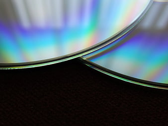 Close-up of iridescent optical disc edge on dark background