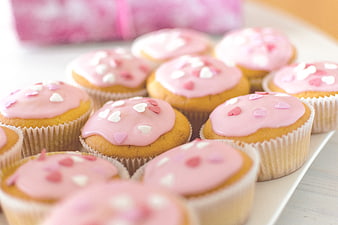 Pink Frosted Cupcakes With Heart Sprinkles On White Plate