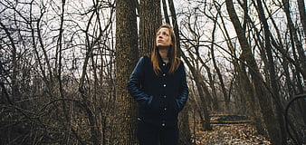 Woman in Blue Jacket Standing in Winter Forest