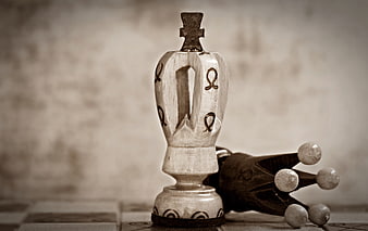 Vintage wooden chess queen and fallen king on a checkered board