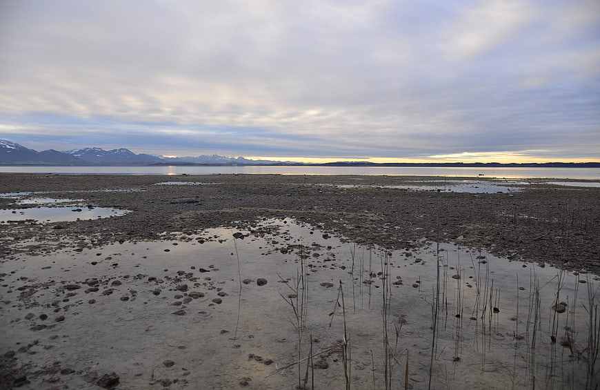 Misty Lake Chiemsee Shoreline with Distant Snowy Mountains