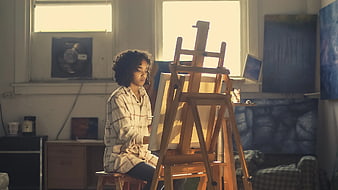 Young Woman Painting on Canvas in Sunlit Studio