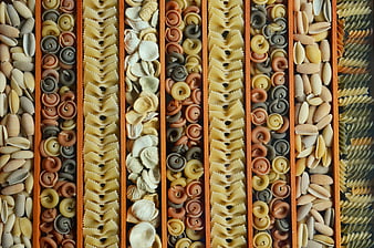 Top View of Sorted Colorful Pasta Shapes in Wooden Compartments