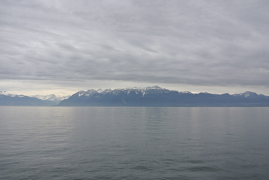 Serene Lake View with Snow-Capped Mountains Under Cloudy Sky