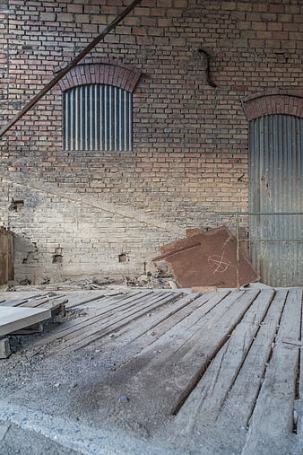 Abandoned brick factory interior with wooden floor and corrugated metal