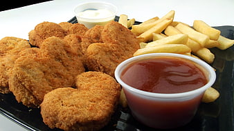 Crispy chicken nuggets with french fries and dipping sauces
