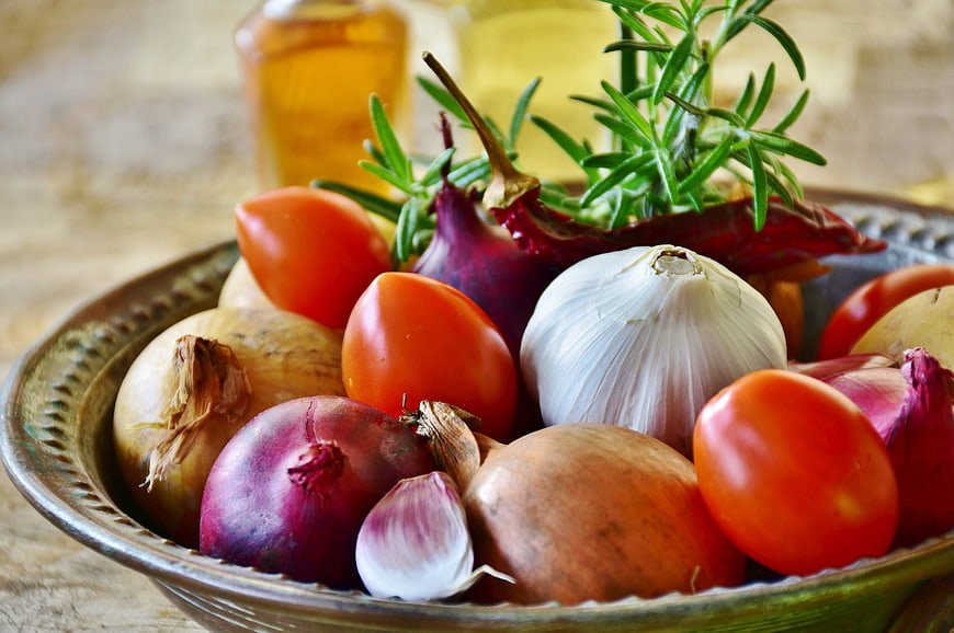 Fresh vegetables and herbs in rustic metal bowl
