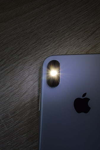 Close-up of iPhone X rear camera and flash on wooden surface
