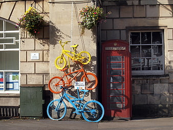 Colorful bicycle sculpture installation next to red telephone booth