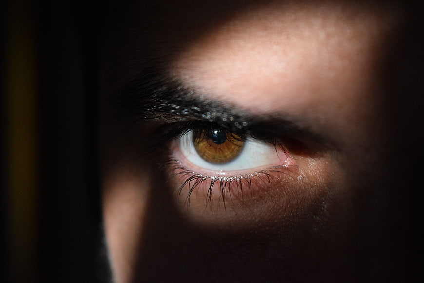 Close-up of a man's eye in dramatic shadow