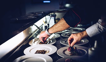 Chefs plating gourmet dishes in a professional kitchen