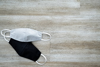 Black and white cloth face masks on wooden background