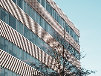 Modern office building facade with diagonal lines and blue sky