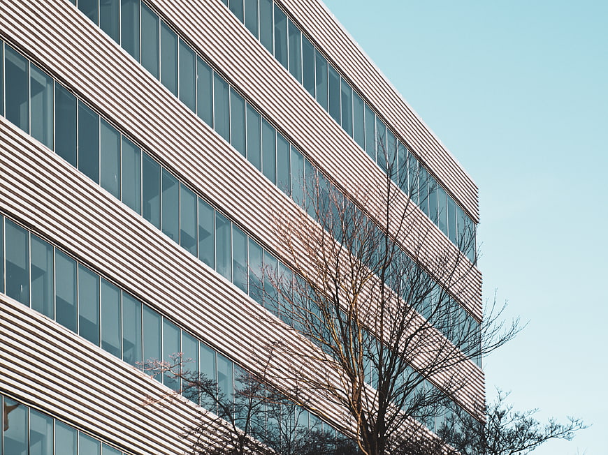 Modern office building facade with diagonal lines and blue sky