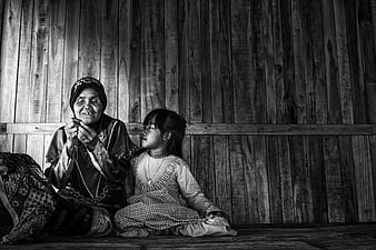 Black and white portrait of grandmother teaching granddaughter to sew