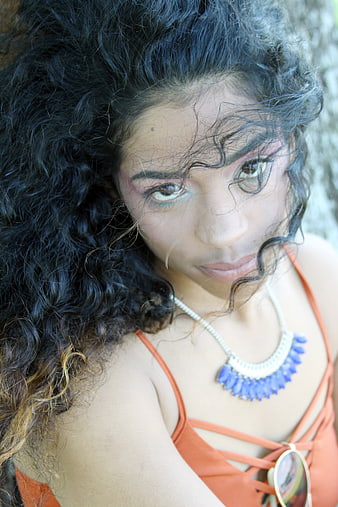 Portrait of Woman with Curly Hair and Blue Necklace