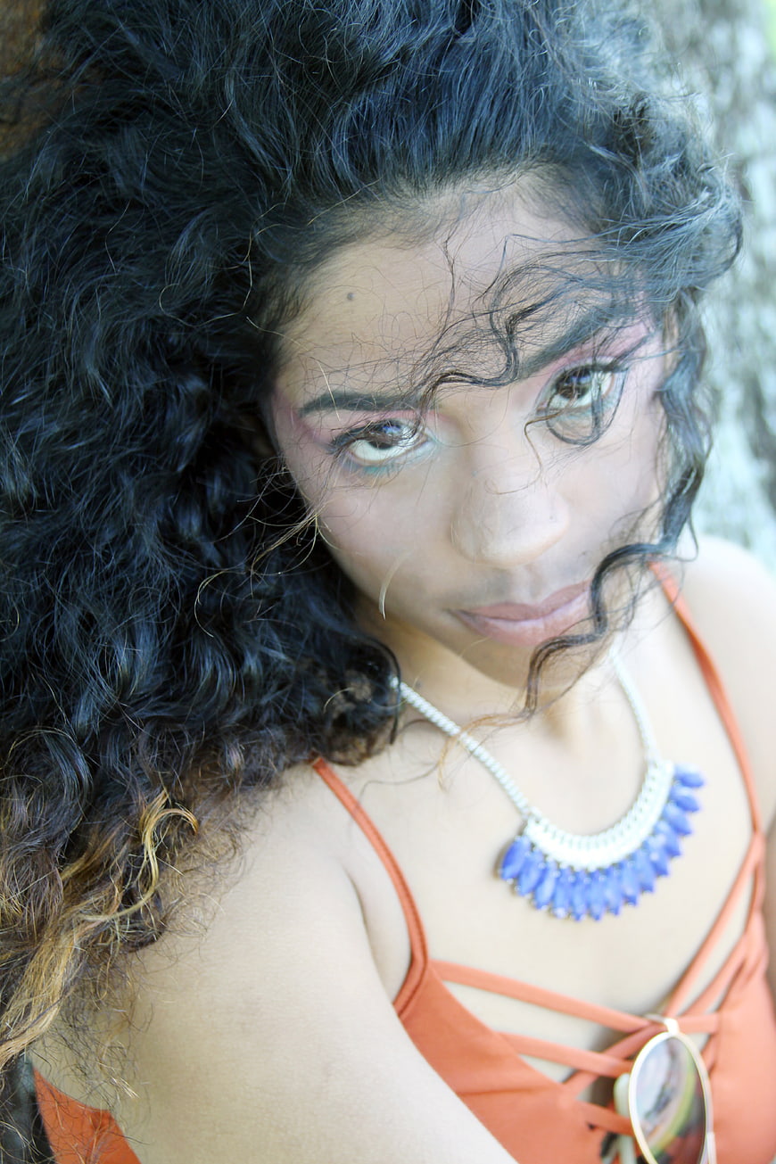 Portrait of Woman with Curly Hair and Blue Necklace
