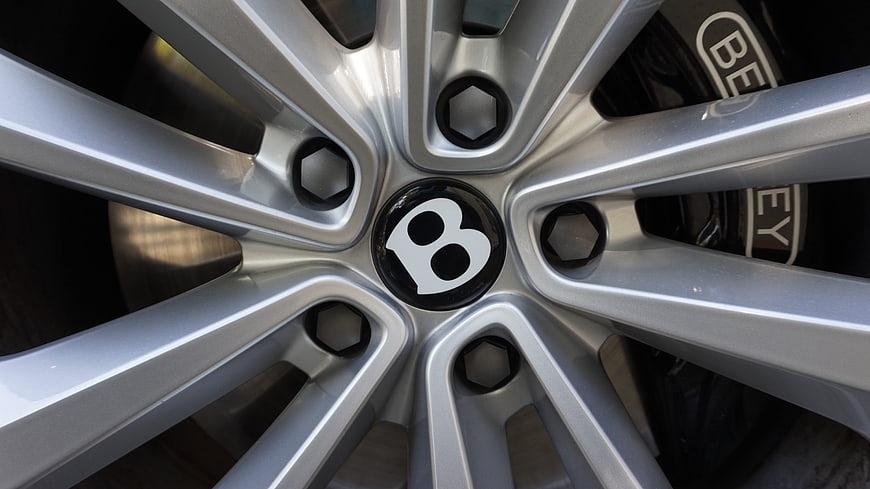 Close-up of silver Bentley car wheel rim with brake caliper