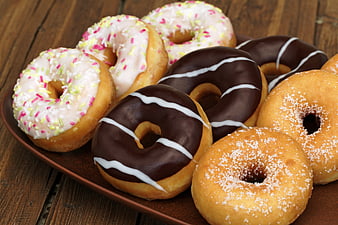 Assorted Glazed and Chocolate Donuts on Wooden Table