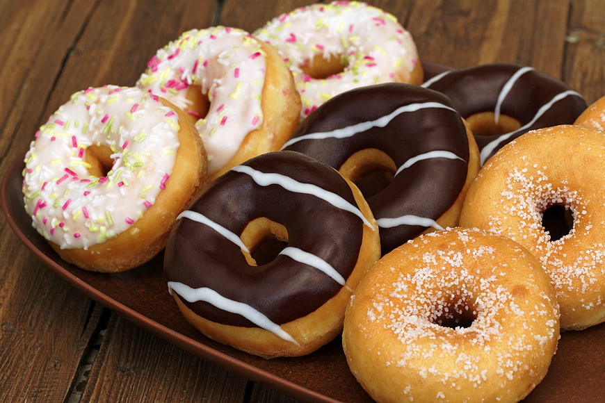 Assorted Glazed and Chocolate Donuts on Wooden Table