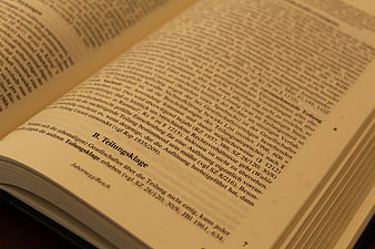 Open legal book with German text on dark background