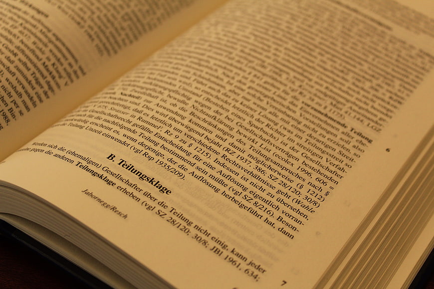 Open legal book with German text on dark background
