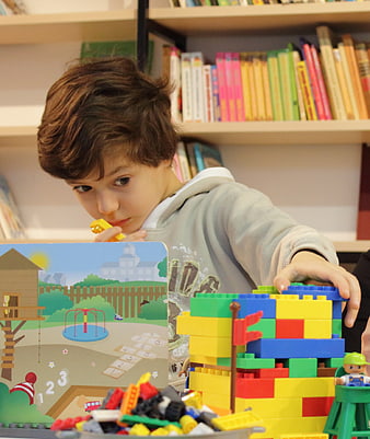Young boy building colorful block tower in library
