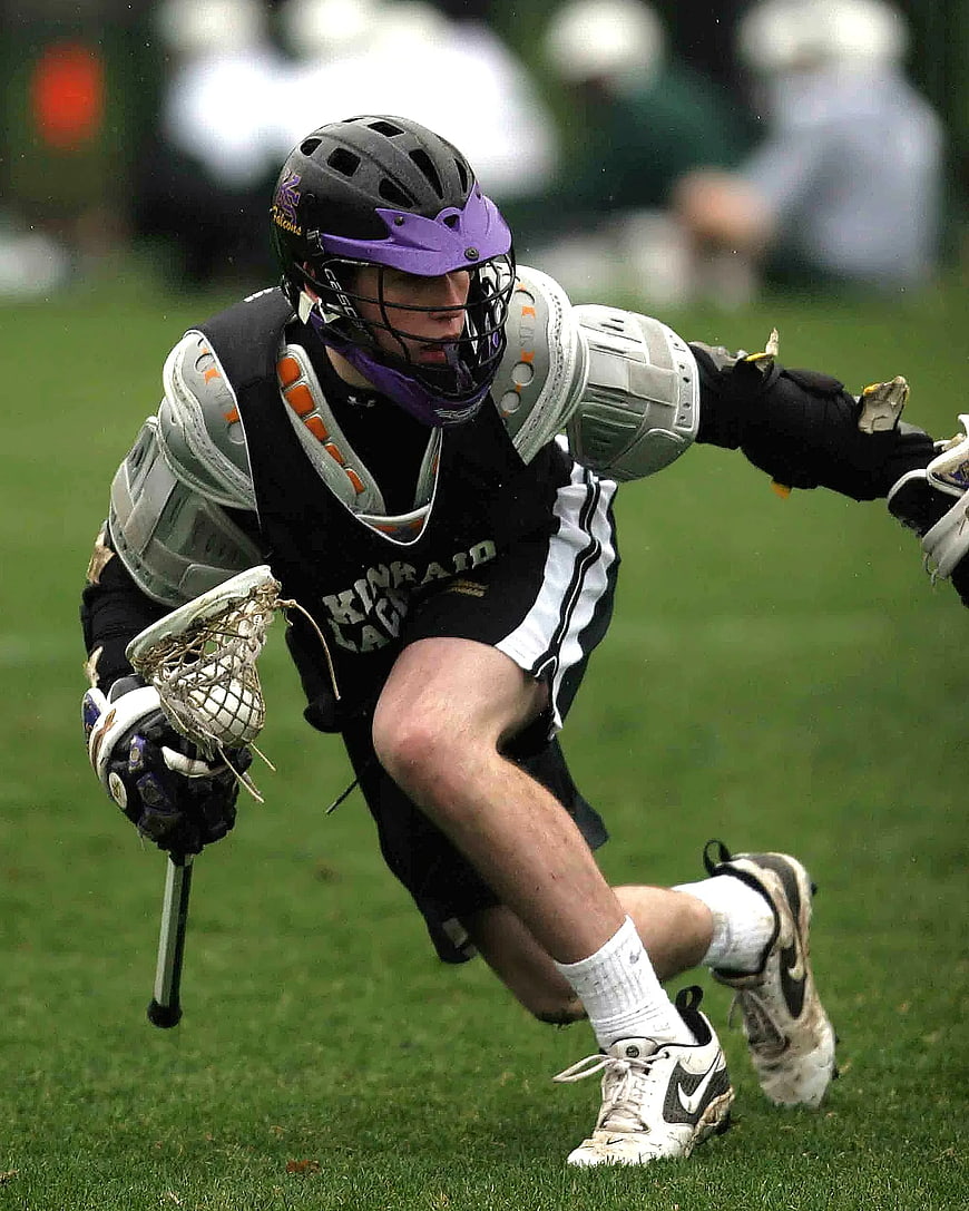 Lacrosse Player Sprinting with Stick on Grass Field