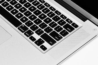 Close-up of a modern laptop keyboard with black keys on a silver chassis
