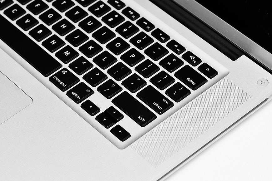 Close-up of a modern laptop keyboard with black keys on a silver chassis