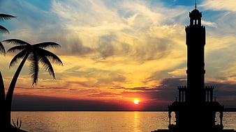 Silhouette of Clock Tower and Palm Trees at Sunset