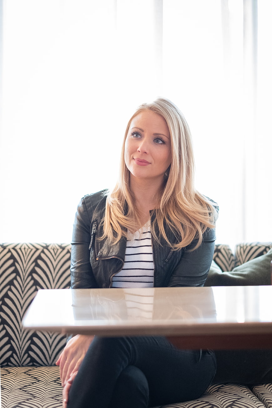 Blonde Woman in Leather Jacket Sitting at Table