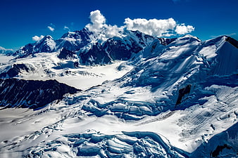 Snow-Covered Mountain Peaks and Glaciers Under Blue Sky