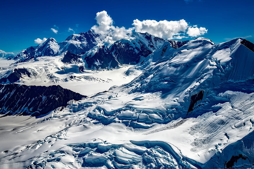 Snow-Covered Mountain Peaks and Glaciers Under Blue Sky