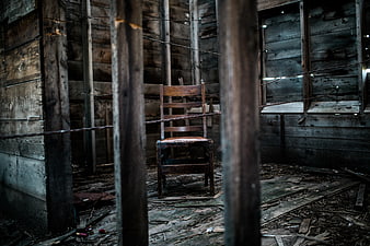 Lonely wooden chair in abandoned rustic cabin interior