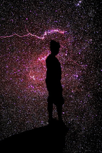 Silhouette of person standing against vibrant starry night sky
