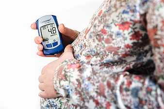 Senior woman holding blue blood glucose meter